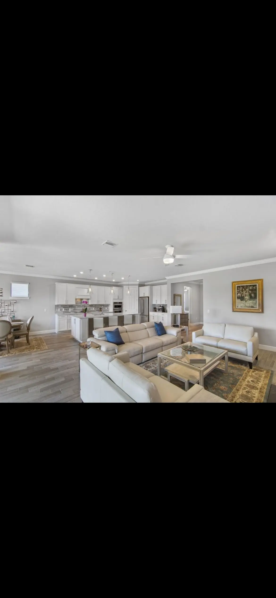 Open-concept kitchen and living room with fresh wall paint and white cabinetry